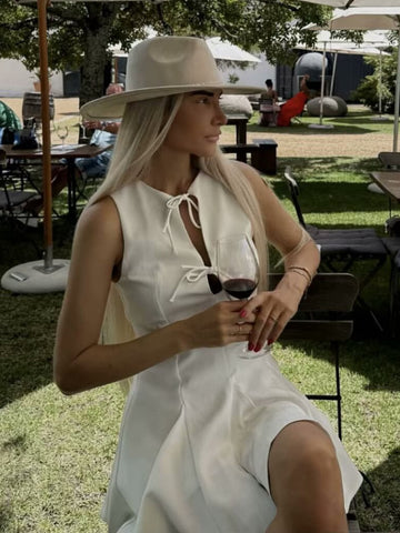 A Sleeveless Dress Decorated With A Bow